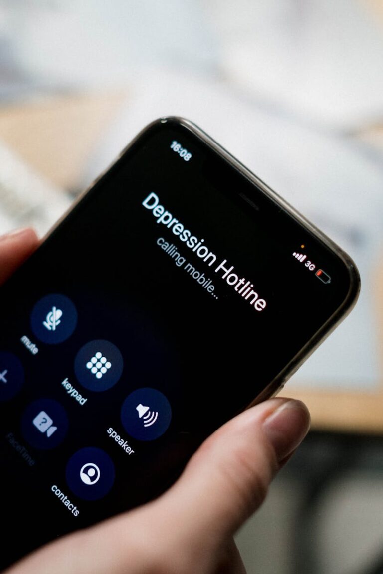 Close-up of a person holding a smartphone, calling a depression hotline.